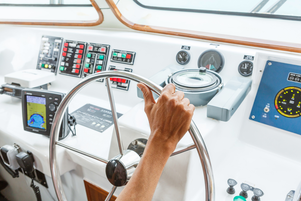 man on steering wheel of yacht