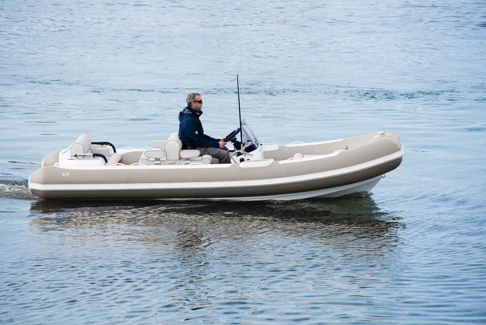 man driving tender boat for yacht